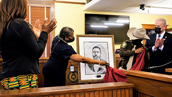 Person unveiling a portrait
