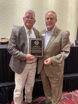 Alan Bristol receives the Distinguished Service Award from Parmer County Commissioner Kirk Frye on behalf of the West Texas Judges and Commissioners Association in 2023.
