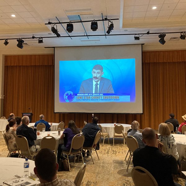 Attendees watching a video on a projector