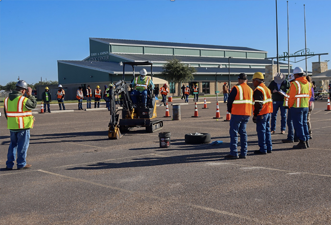 People in reflective vests standing outside of a building
