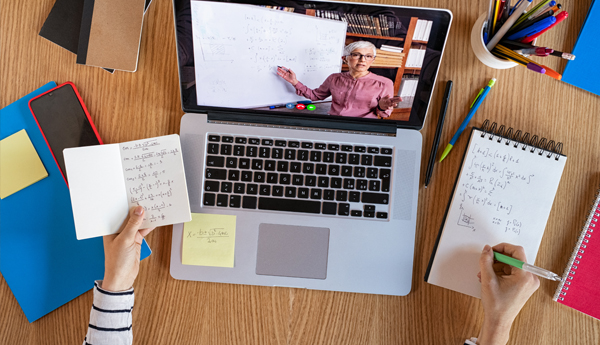 Person taking notes while on a facetime call on their computer