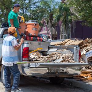 Pickup truck picking up broken pieces of something after a hurricane