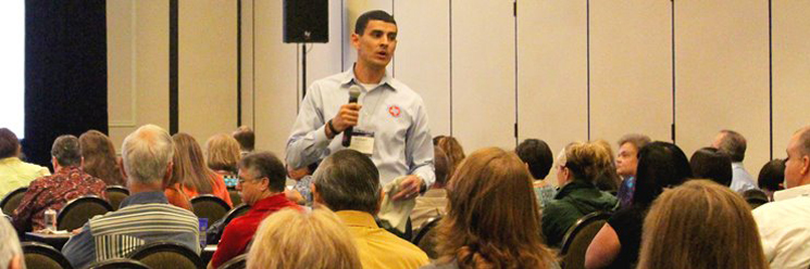 Person speaking to room of seated people